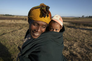 Eine Mutter trägt ihr Kind in einem Tuch auf dem Rücken. (Quelle: Frank Peterschröder)