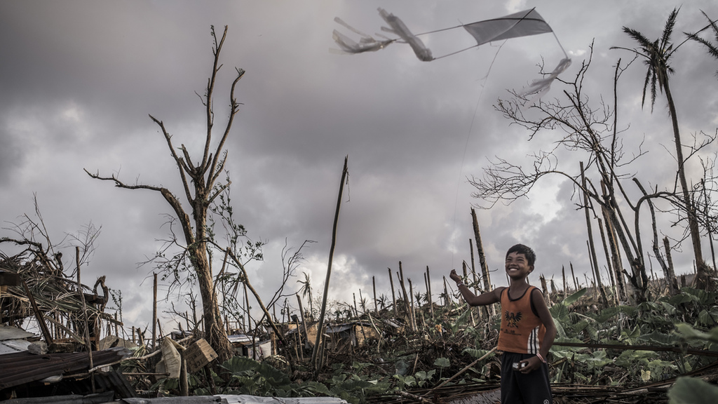 Nach dem Taifun Haiyan spielt ein Jungen in seinem zerstörten Dorf mit seinem Drachen. (Quelle: Jakob Studnar)