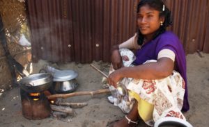 Eine Frau kocht auf einem kleinen Holzofen. (Quelle: Jens Großmann)