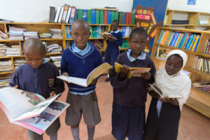 Kinder mit Büchern in einer Bibliothek. (Quelle: Stefan Trappe)