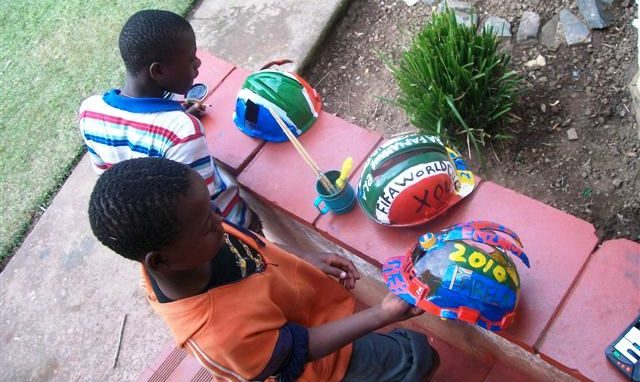 Südafrikanische Kinder haben Helme bemalt. (Quelle: Kindernothilfe-Partner)