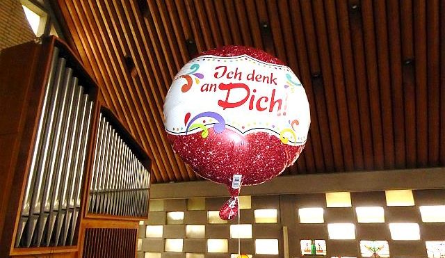 Ein Luftballon mit der Aufschrift "Ich denk an dich" schwebt unter dem Kirchendach. (Quelle: privat)