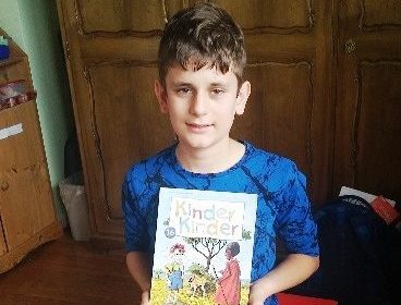 Ein Junge hält eine Kinderzeitschrift in den Händen