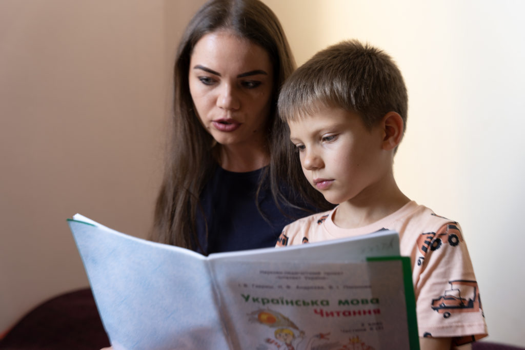 Elena und ihr Sohn Ivan lesen in einem ukrainischen Schulheft (Quelle: Christian Nusch)