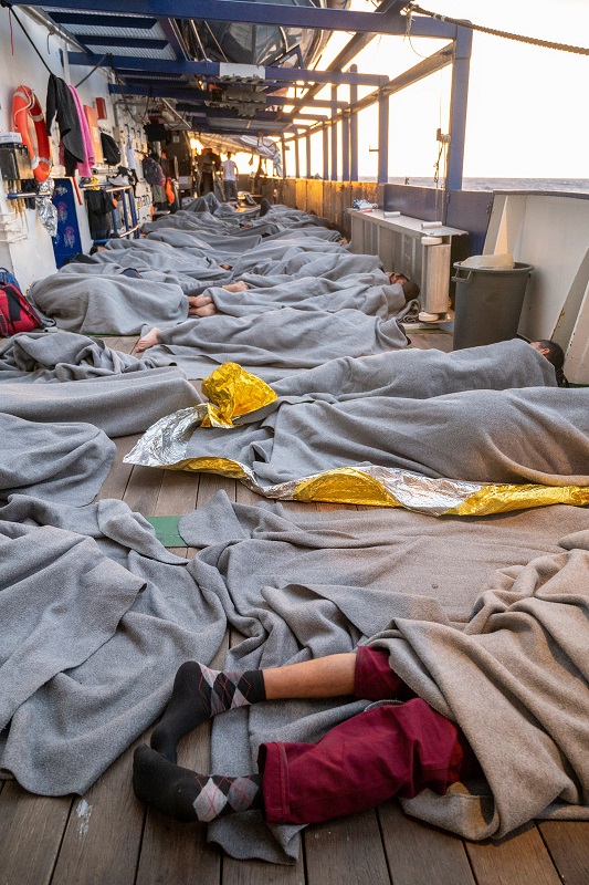 Die Männer liegen dicht an dicht auf Deck und schlafen dort (Quelle: Arez Ghaderi/SOS Humanity)