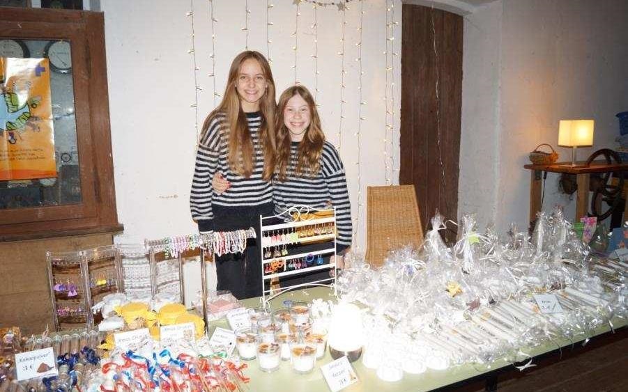 Zwei Mädchen Arm in Arm hinter einem Verkaufstisch (Quelle: privat)